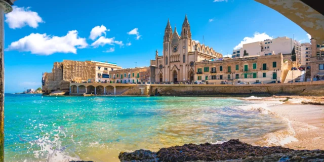 A view of the water and buildings from under an arch.