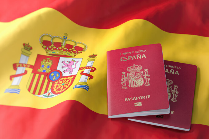 A passport sitting on top of an spain flag.