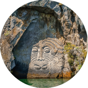 Rock carving of a face by water.